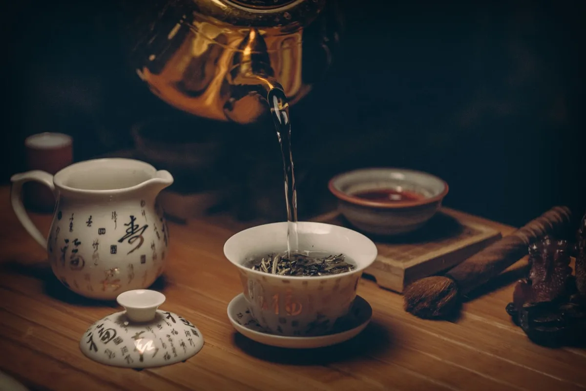 A gold kettle pouring steaming hot water in a warm kitchen