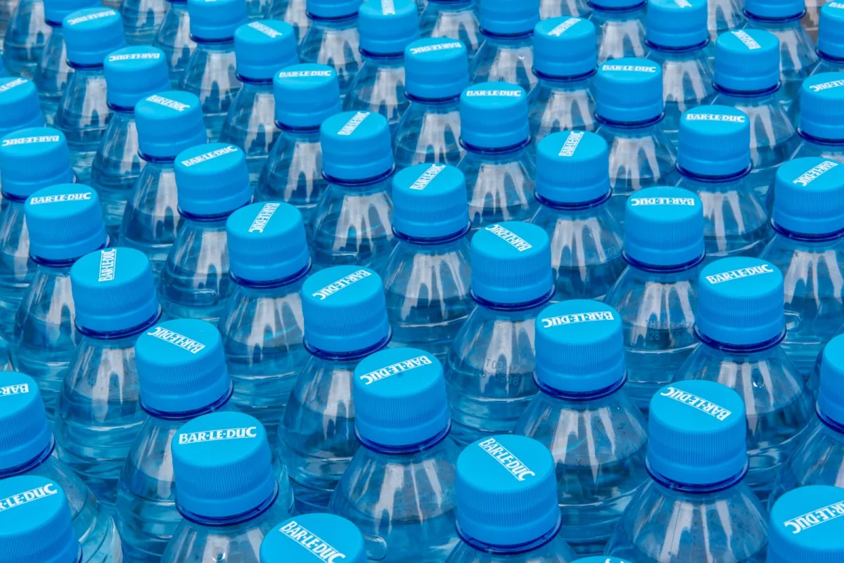 Several clear plastic water bottles stacked in bright light