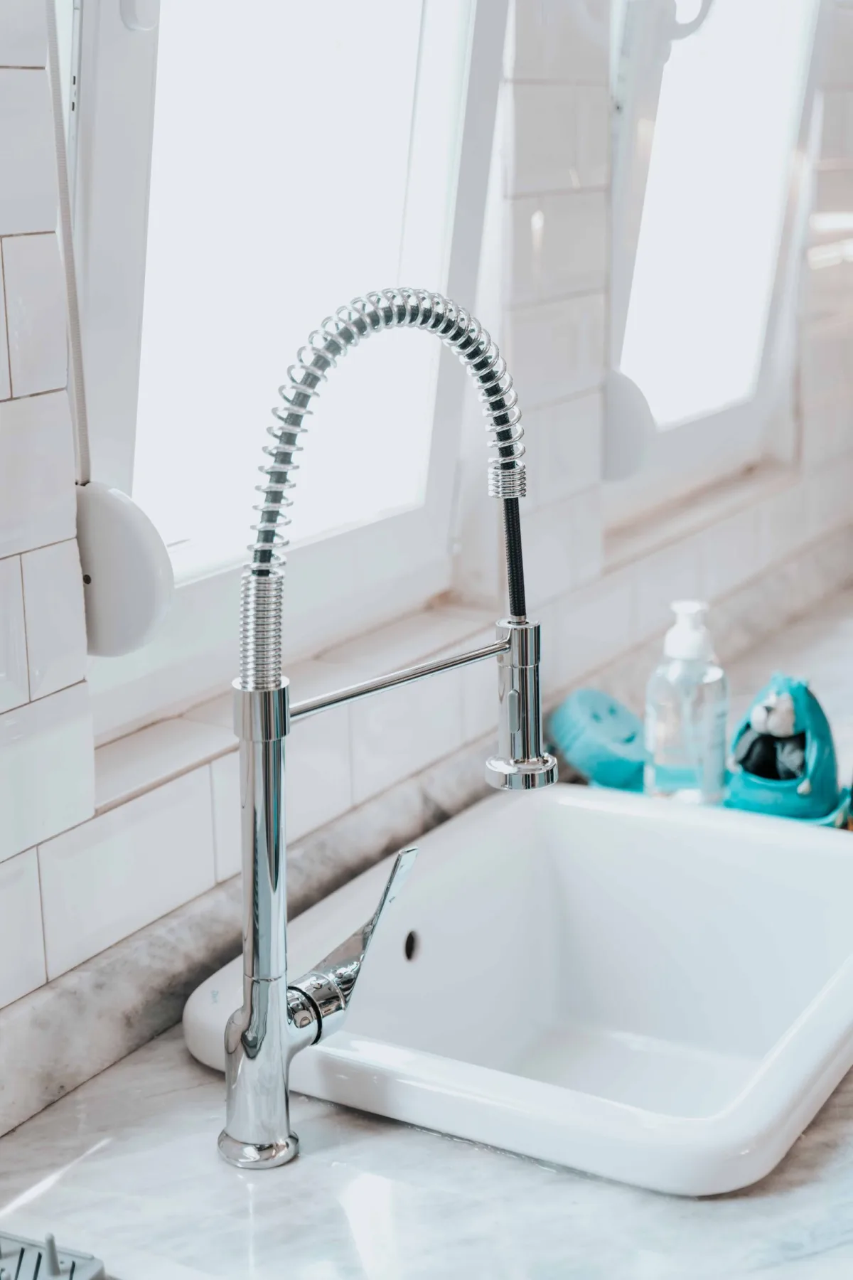 A home kitchen faucet and sink in warm natural light