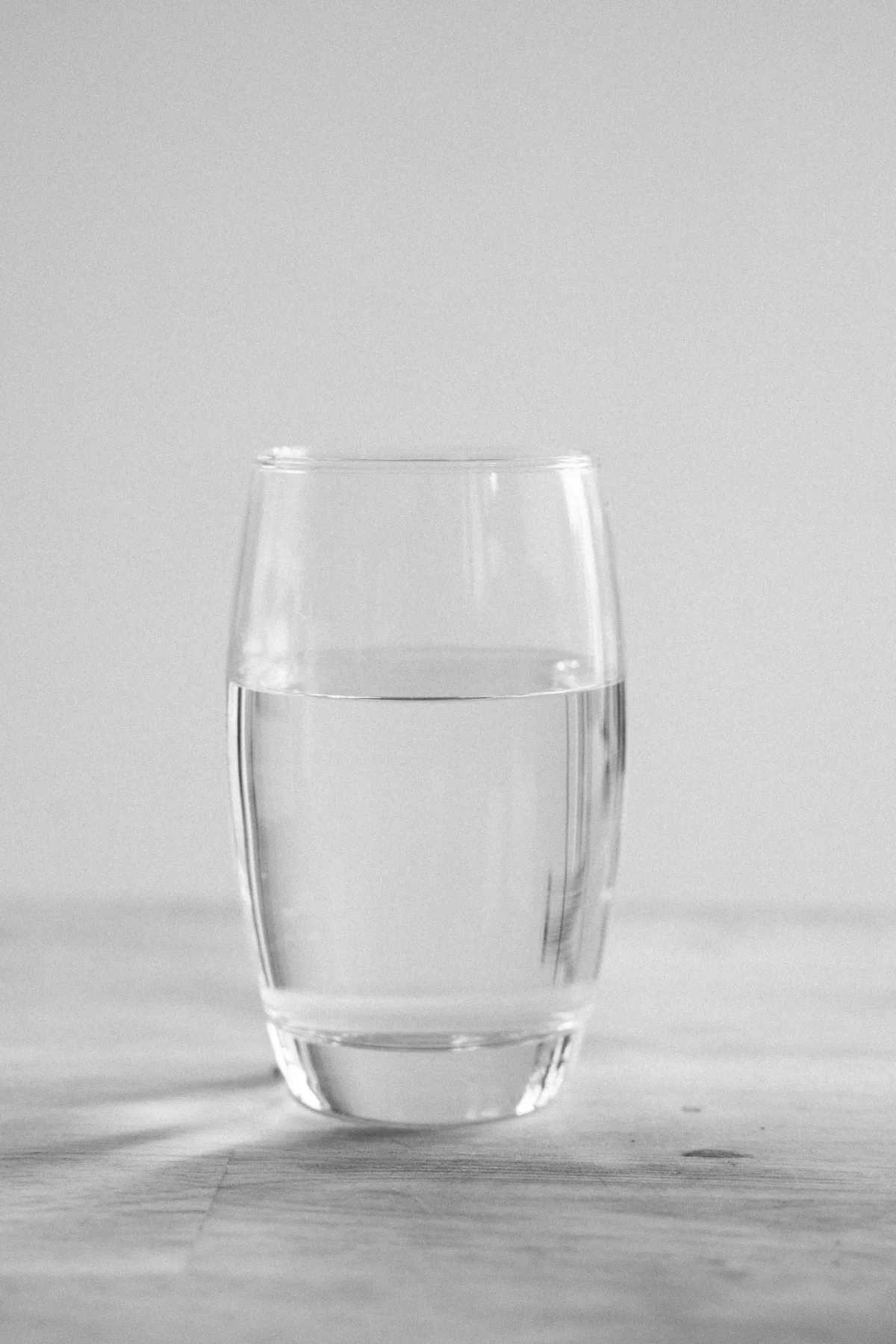 A bright, clear glass of drinking water on a clean light surface